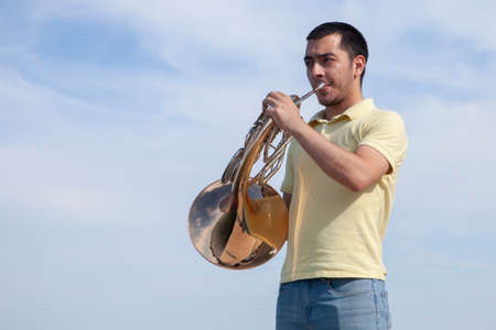 Portrait of teen musician playing instrument classic french horn. Close-upの写真素材