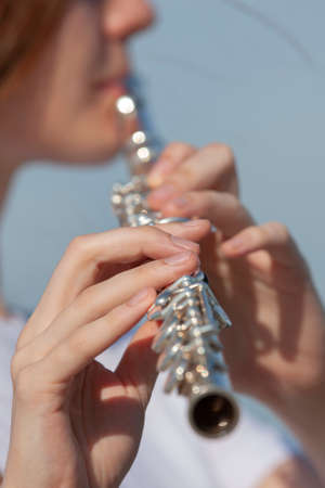 Girl playing the flute in the garden. Portraitの写真素材