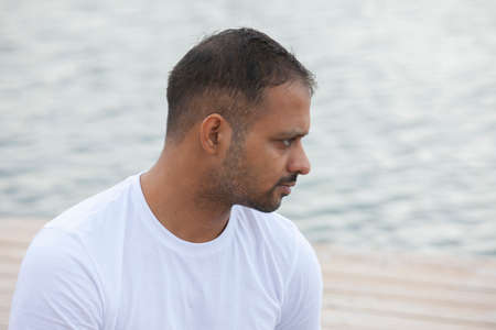 Profile shot of mature man meditating in lotus position on pier against lake Portrait