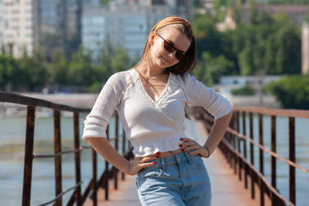 Young woman on the pier at the river. Portrait