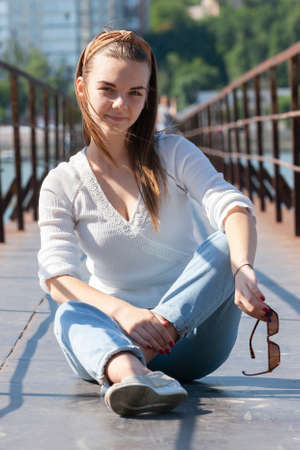 Young woman on the pier at the river. Portrait