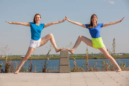 Two beautiful women meditating in the park. Portrait