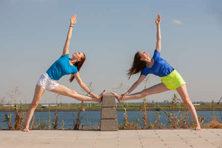 Two beautiful women meditating in the park. Portraitの写真素材