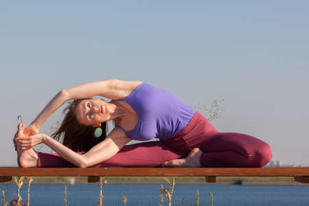 Young girl doing yoga in the park. Portrait