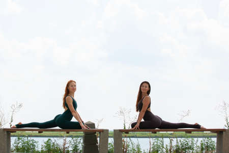 Two women doing yoga outdoors. yoga instructor shows poses. Portraitの写真素材