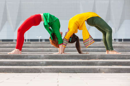 Two females doing yoga in the nature. Healthy life style. Exercise in nature. Portrait.の写真素材