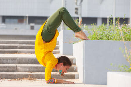Pretty woman doing yoga exercises in the park. Portrait.