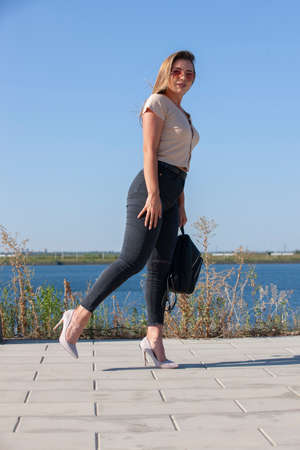 Portrait of young european woman is standing near the lake, beautiful european woman in nature,...