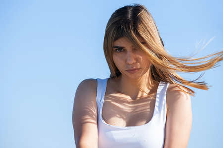 Portrait of girl in the park in a white dress near river in a sunny or a spring dayの写真素材
