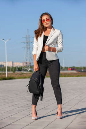 Elegant confident woman walking along the river in city park and smiling, full height. Portrait.の写真素材