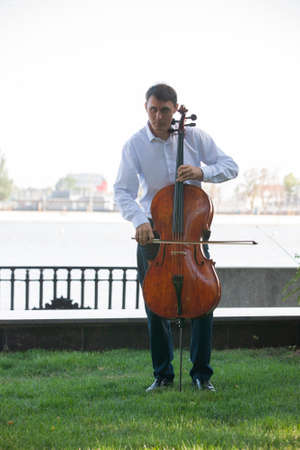 The musicians are playing cello with sunlight. Portrait.の写真素材