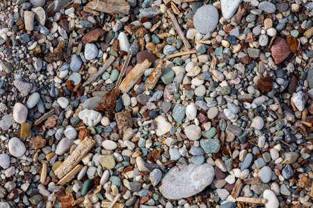 Stones texture. Background the damp multi-colored pebbles close up soft focus from on the pebbly beach in cloudy weather. Limited depth of fieldの写真素材