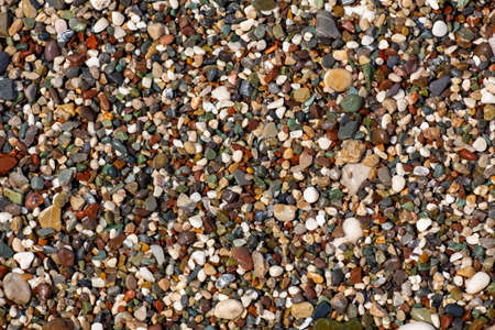 Stones texture. Background the damp multi-colored pebbles close up soft focus from on the pebbly beach in cloudy weather. Limited depth of fieldの写真素材