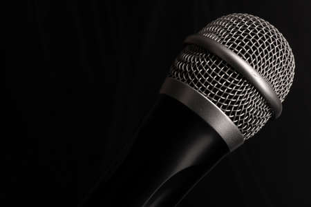 Close-up black microphone head isolated on black background. Image can be used as background. There is a place for text.の写真素材