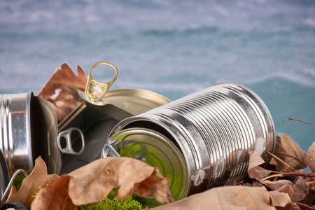 Still life of an empty used tin can with lid and pull waste on forest floor as an environmental pollution closeup. Backgroundの写真素材