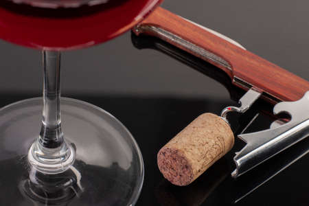 High angle view with shallow depth of field of a glass of red wine with a sommelier tools. Close-up.の写真素材