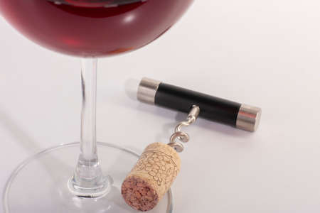 High angle view with shallow depth of field of a glass of red wine with a corkscrew. Close-up.の写真素材