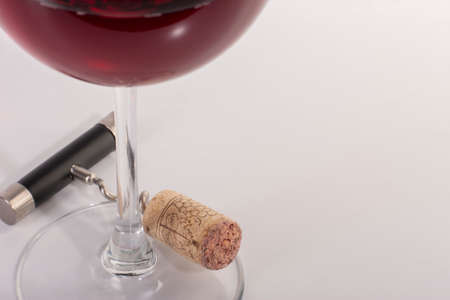 High angle view with shallow depth of field of a glass of red wine with a corkscrew. Close-up.の写真素材