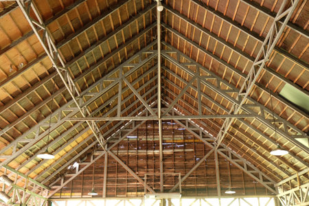 An old building with a gable-shaped wooden and steel roof structure.
