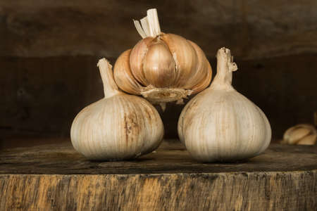 garlics on wooden cutting board.