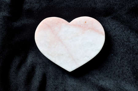 heart shaped stone on black fabric の写真素材