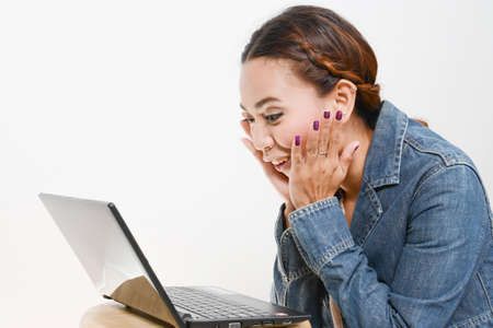 Surprised girl looking in laptop, facial expression の写真素材