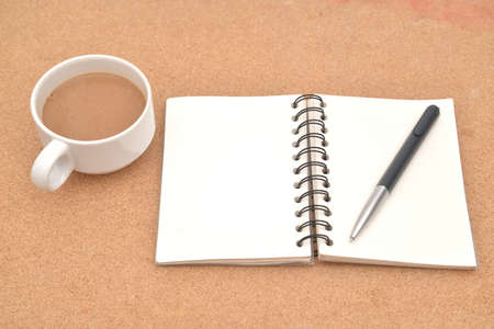 Blank Spiral Note Pad, Cup of Coffee and Pen on Wood Background.の写真素材