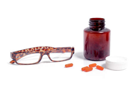 Pills spilling out of pill bottle isolated on whiteの写真素材