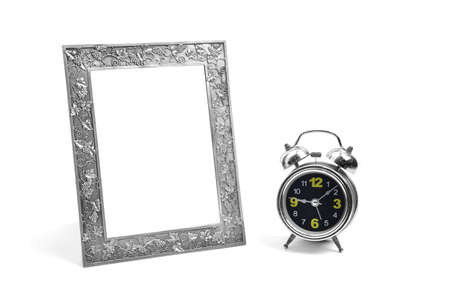 Silver picture frame and alarm clock isolated over whiteの写真素材