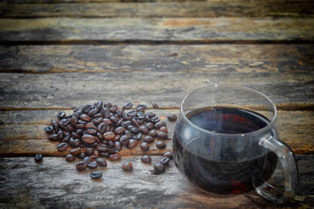 Coffee cup and coffee beans on a wooden table. Vintage color toneの写真素材