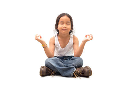 Relaxed child practicing yoga on a white backgroundの写真素材