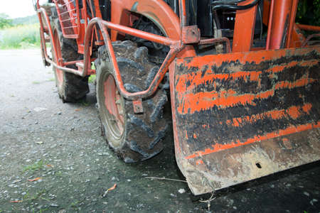 Dirty orange farm Tractor in the farmの写真素材