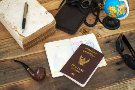 passport and globe on wooden table with tobacco pipe and sunglass.の写真素材