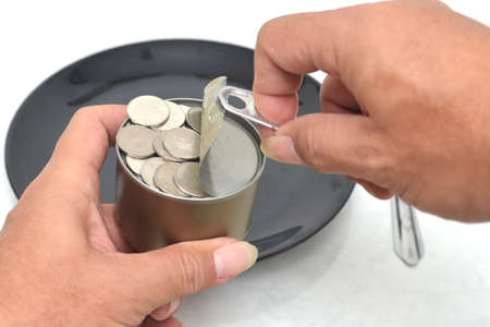 Canned Money in hand. Ready to put on a plate.の写真素材