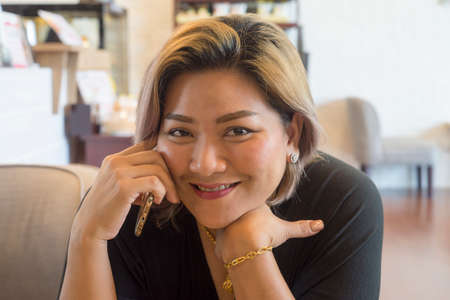 smiling woman talking on the phone looking at the camera.