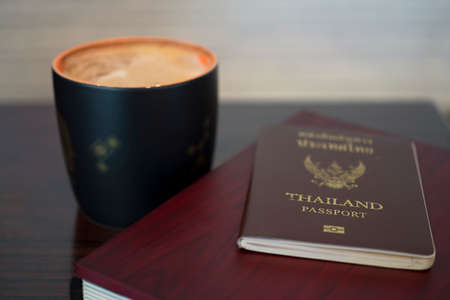 Thai passport with coffee cup on wooden tableの写真素材