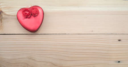 Heart shaped gift box against wooden backgroundの写真素材