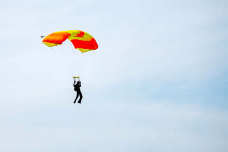 Parachutist on blue sky preparing for landingの写真素材