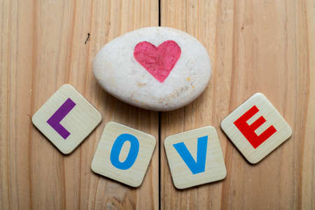alphabet written word " Love " with stone painting heartの写真素材