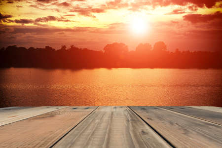 wood terrace with sunrise and sunset sky background.の写真素材