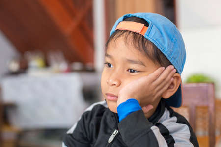 Boy sitting on the table, thinking about something.