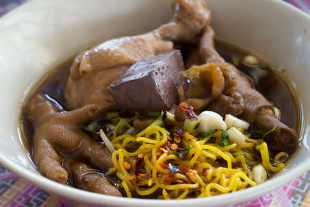 bowl of noodles with braised chicken.の写真素材