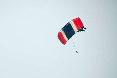 Parachutist on blue sky preparing for landingの写真素材