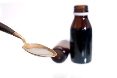liquid medicine to children in a brass spoon on a white background.の写真素材