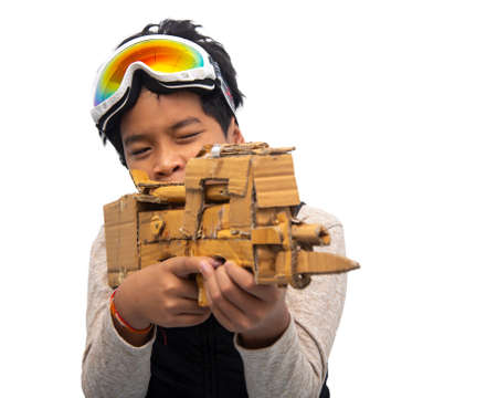 Asian boy holding a gun made of Corrugated Cardboard.Corrugated Cardboard can be reused as a toy...