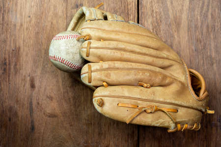 Vintage classic leather baseball glove isolated on wooden backgroundの写真素材