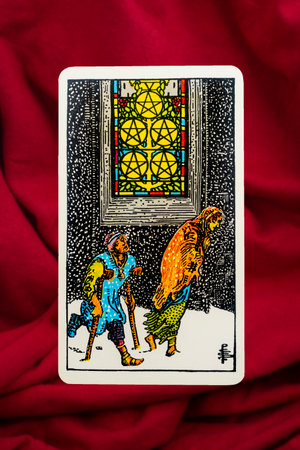 Yala Province, Thailand, June 1, 2022- Five of Pentacles Tarot Card of Rider Waite deck on red fabric background.のeditorial素材