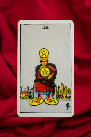 Yala Province, Thailand, June 1, 2022- Four of Pentacles Tarot Card of Rider Waite deck on red fabric background.のeditorial素材