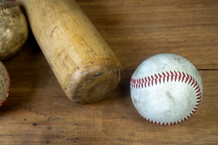 Close up old baseball and wooden baseball bat on a woodeb table. select focus.の写真素材