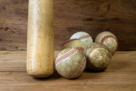 Close up old baseball and wooden baseball bat on a woodeb table. select focus.の写真素材